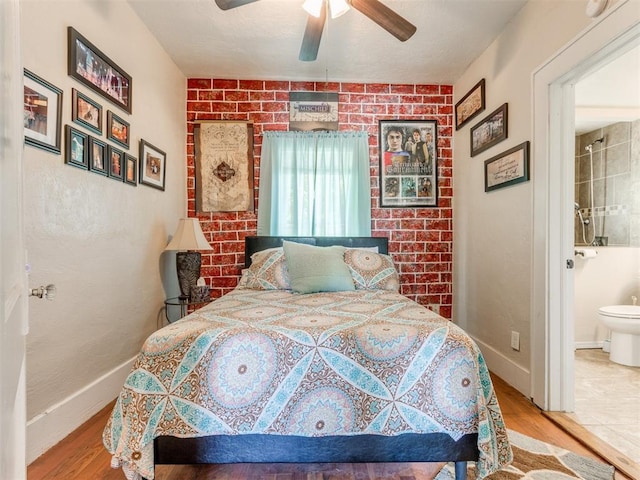 bedroom featuring wood finished floors, ceiling fan, connected bathroom, and baseboards