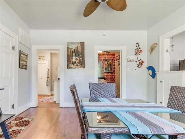 dining space with ceiling fan, wood finished floors, and baseboards