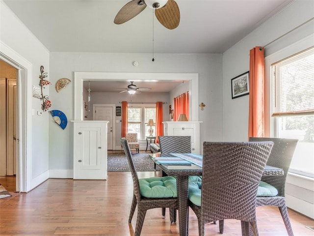 dining space with ceiling fan, wood finished floors, and baseboards