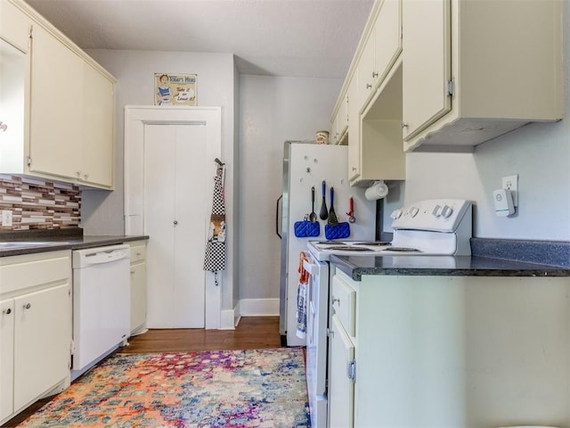 kitchen featuring white appliances, wood finished floors, dark countertops, and backsplash