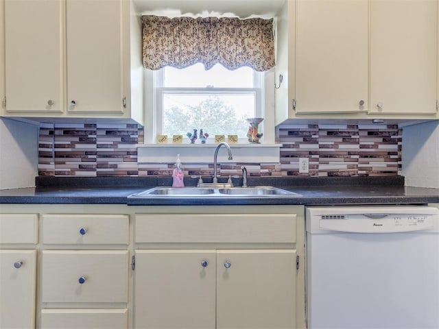 kitchen featuring dishwasher, a sink, dark countertops, and backsplash