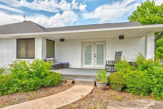 16070 N County Road 3264, Pauls Valley, OK 73075 - view of exterior entry with french doors, a shingled roof, covered porch, and brick siding