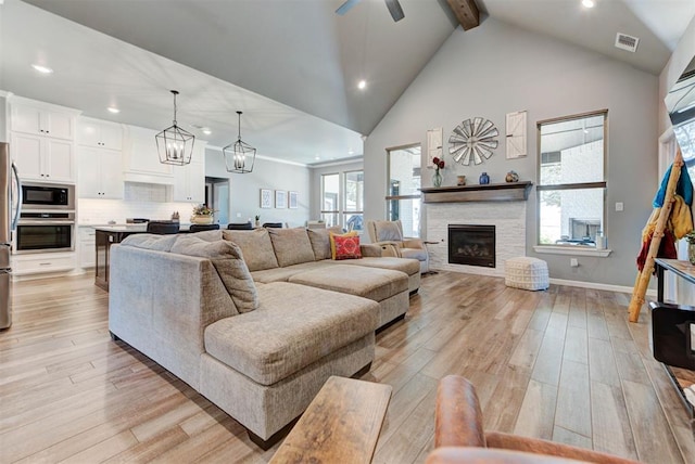 8624 Grey Wind Way, Arcadia, OK 73007 - living room with recessed lighting, beamed ceiling, light wood finished floors, a ceiling fan, and a stone fireplace