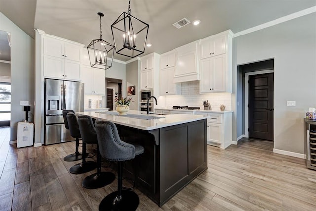 8624 Grey Wind Way, Arcadia, OK 73007 - kitchen with stainless steel appliances, tasteful backsplash, wood finished floors, light countertops, and a sink