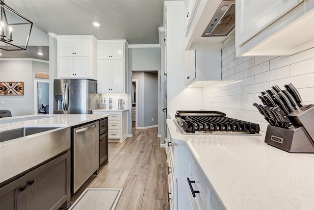 8624 Grey Wind Way, Arcadia, OK 73007 - kitchen with appliances with stainless steel finishes, wall chimney exhaust hood, tasteful backsplash, light countertops, and white cabinets