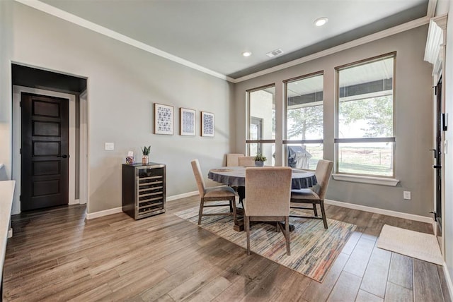 8624 Grey Wind Way, Arcadia, OK 73007 - dining room with wood finished floors, crown molding, baseboards, recessed lighting, and wine cooler