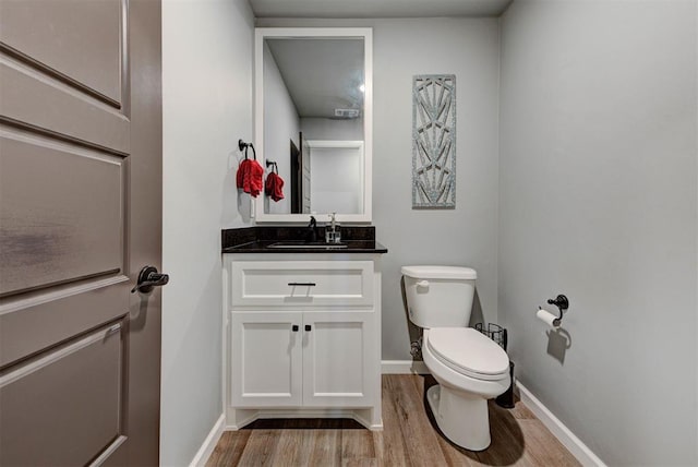 8624 Grey Wind Way, Arcadia, OK 73007 - half bath featuring wood finished floors, toilet, vanity, and baseboards