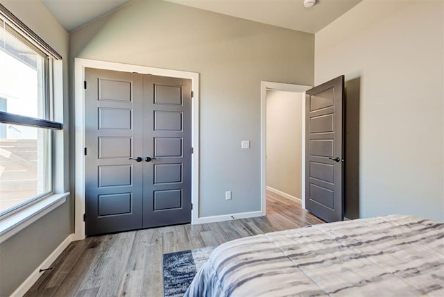 8624 Grey Wind Way, Arcadia, OK 73007 - bedroom with wood finished floors, a closet, baseboards, and lofted ceiling