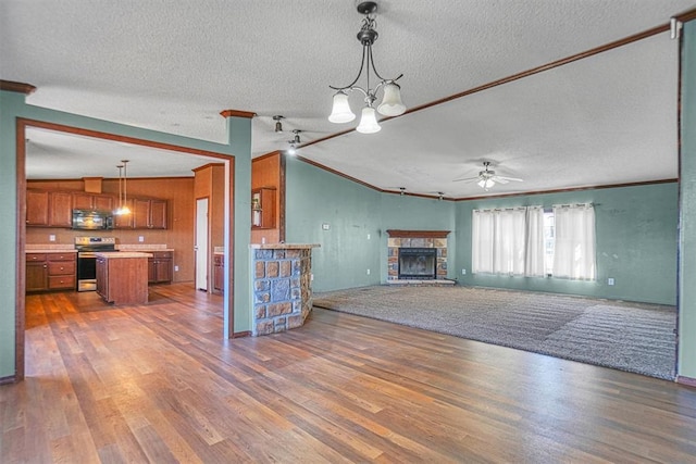 20930 E 1060th Rd, Canute, OK 73626 - unfurnished living room featuring ornamental molding, a textured ceiling, wood finished floors, ceiling fan, and a fireplace