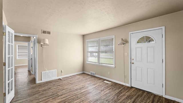 4313 SE 13th St, Oklahoma City, OK 73115 - foyer entrance featuring a textured ceiling, wood finished floors, baseboards, and french doors