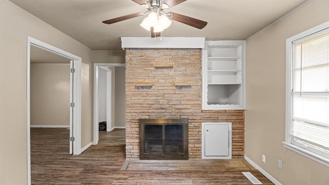 4313 SE 13th St, Oklahoma City, OK 73115 - unfurnished living room featuring a stone fireplace, ceiling fan, wood finished floors, baseboards, and ornamental molding