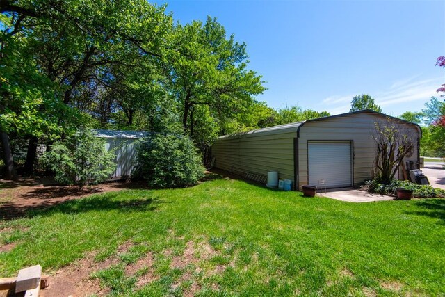 13351 El Zorro, Edmond, OK 73034 - view of green lawn featuring an outdoor structure and a garage