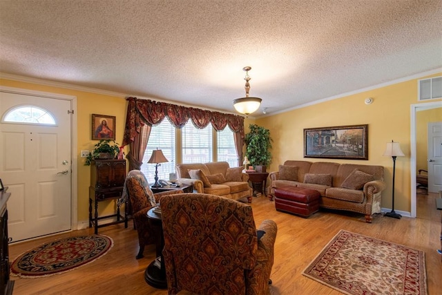 13351 El Zorro, Edmond, OK 73034 - living room featuring a textured ceiling, light wood-type flooring, crown molding, and vaulted ceiling