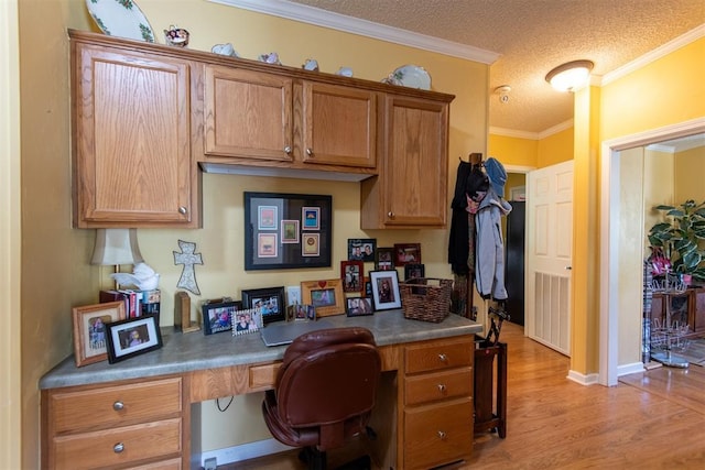 13351 El Zorro, Edmond, OK 73034 - office space with built in study area, light wood finished floors, a textured ceiling, and ornamental molding