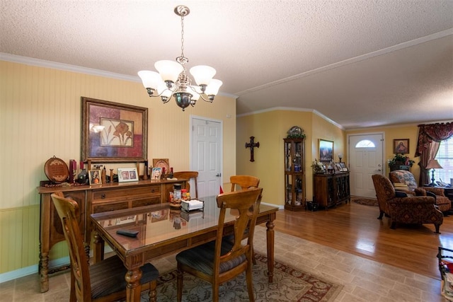 13351 El Zorro, Edmond, OK 73034 - dining area with a chandelier, ornamental molding, a textured ceiling, and light wood-style flooring