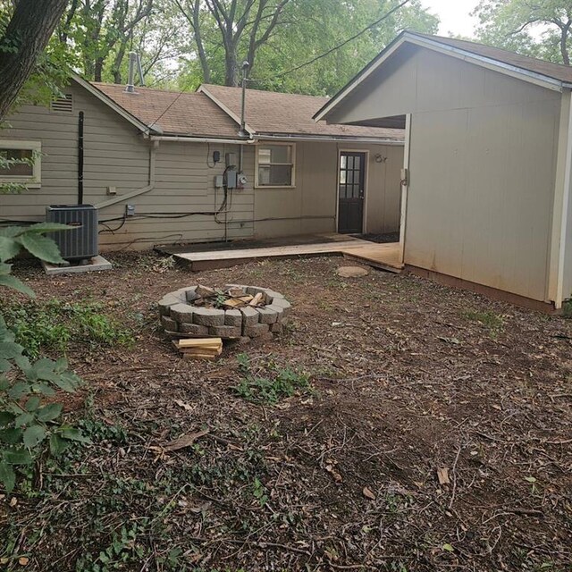 1015 W 10th Ave, Stillwater, OK 74074 - rear view of property with a fire pit, cooling unit, and roof with shingles