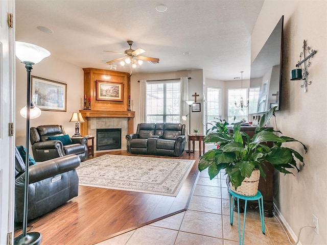 1512 Selborne Pl, Yukon, OK 73099 - living area with ceiling fan, healthy amount of natural light, a tiled fireplace, and a chandelier