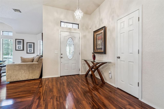 1721 Park View Pl, Edmond, OK 73003 - entrance foyer featuring dark wood-style flooring, a chandelier, baseboards, vaulted ceiling, and a textured wall