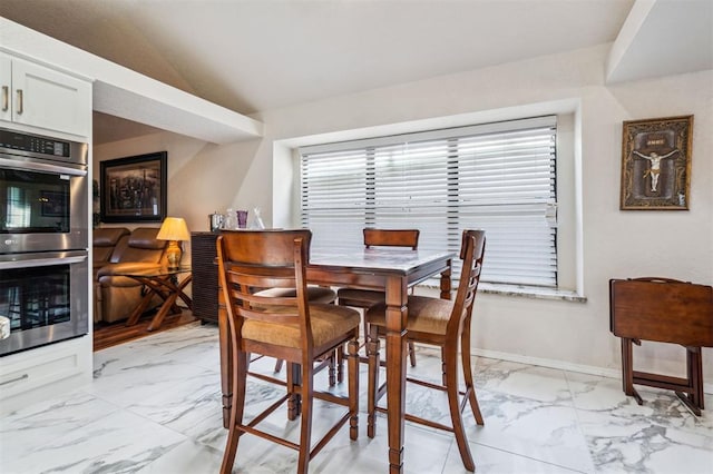 1721 Park View Pl, Edmond, OK 73003 - dining room with light marble finish flooring, vaulted ceiling, and baseboards