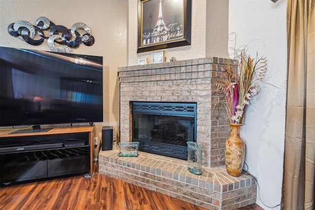 1721 Park View Pl, Edmond, OK 73003 - living area featuring wood finished floors, a textured wall, and a fireplace