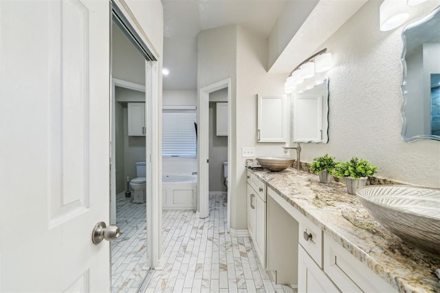 1721 Park View Pl, Edmond, OK 73003 - full bathroom with toilet, double vanity, and baseboards