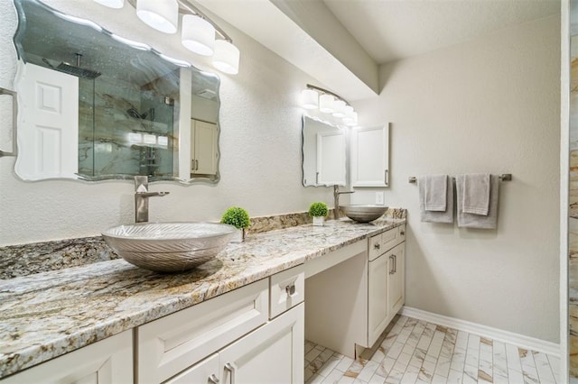 1721 Park View Pl, Edmond, OK 73003 - full bathroom featuring a marble finish shower, double vanity, and baseboards