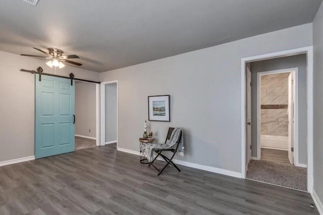 4017 Mallard Dr, Oklahoma City, OK 73115 - sitting room featuring a ceiling fan, a barn door, baseboards, and wood finished floors