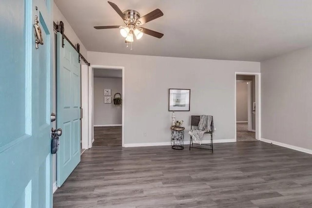 4017 Mallard Dr, Oklahoma City, OK 73115 - foyer featuring a barn door, a ceiling fan, wood finished floors, and baseboards