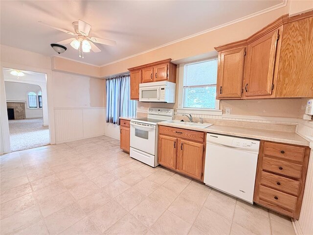 1710 W Chickasha Ave, Chickasha, OK 73018 - kitchen with white appliances, a sink, ceiling fan, light countertops, and wainscoting