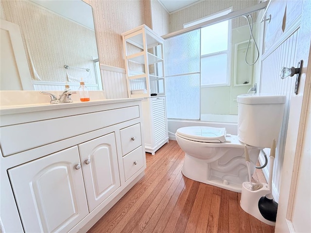 1710 W Chickasha Ave, Chickasha, OK 73018 - full bathroom featuring wallpapered walls, toilet, wood finished floors, shower / bath combination with glass door, and vanity