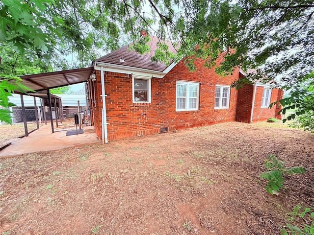 1710 W Chickasha Ave, Chickasha, OK 73018 - back of property with brick siding, crawl space, and a shingled roof