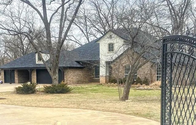 4800 NE 84th Ave, Norman, OK 73026 - french country home featuring a front lawn, concrete driveway, and roof with shingles