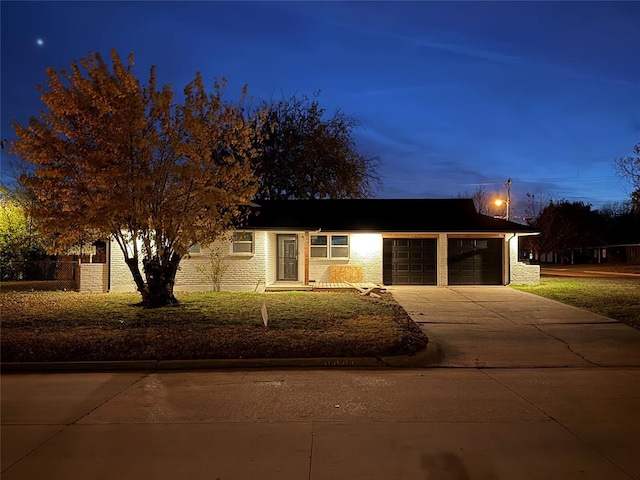 view of front of house with a garage, concrete driveway, brick siding, and a front yard