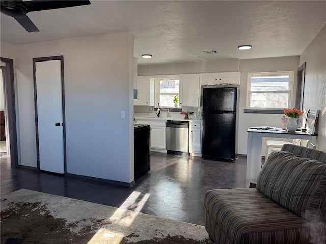 kitchen featuring freestanding refrigerator, dishwasher, finished concrete flooring, white cabinets, and light countertops