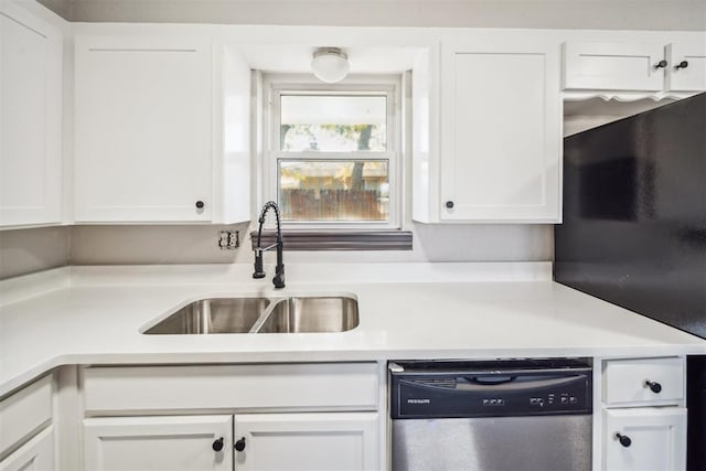 kitchen featuring stainless steel dishwasher, a sink, white cabinetry, and light countertops