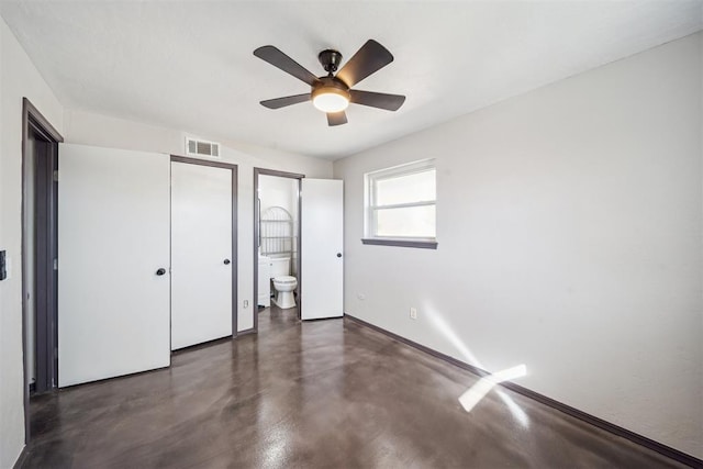 unfurnished bedroom featuring concrete flooring, baseboards, ensuite bathroom, and a ceiling fan