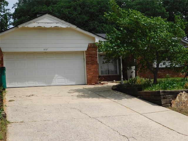 5737 NW 31st St, Oklahoma City, OK 73122 - view of front of home with brick siding, driveway, and a garage