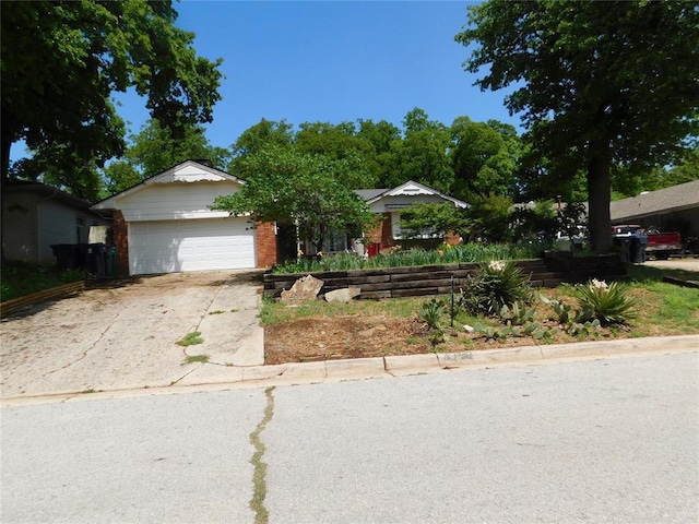 5737 NW 31st St, Oklahoma City, OK 73122 - view of front of home featuring concrete driveway, a garage, and brick siding