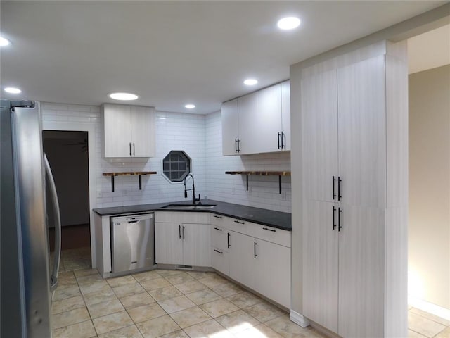5737 NW 31st St, Oklahoma City, OK 73122 - kitchen with appliances with stainless steel finishes, a sink, dark countertops, white cabinets, and recessed lighting