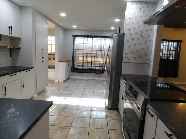 5737 NW 31st St, Oklahoma City, OK 73122 - kitchen featuring appliances with stainless steel finishes, wall chimney range hood, dark countertops, white cabinets, and recessed lighting
