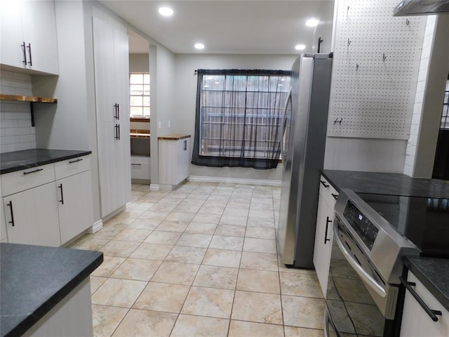 5737 NW 31st St, Oklahoma City, OK 73122 - kitchen with stainless steel appliances, dark countertops, recessed lighting, white cabinets, and light tile patterned flooring