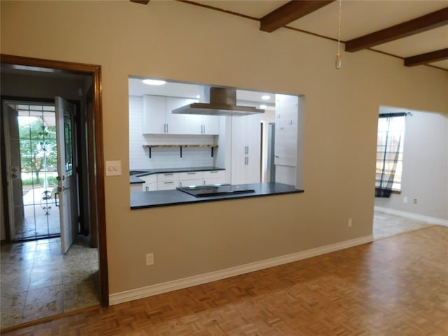 5737 NW 31st St, Oklahoma City, OK 73122 - kitchen with black electric stovetop, beamed ceiling, baseboards, white cabinetry, and tasteful backsplash