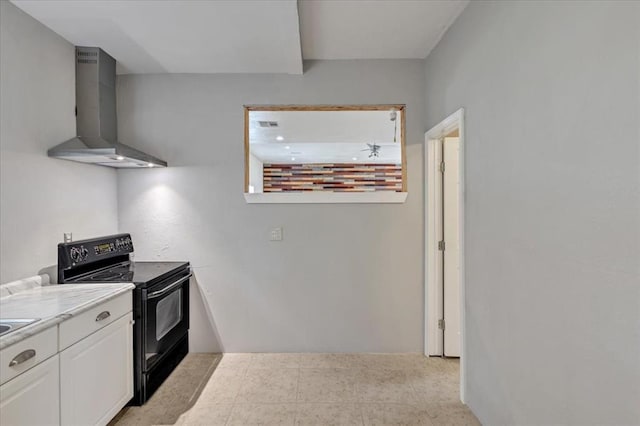 1126 SW 19th St, Oklahoma City, OK 73108 - kitchen featuring electric range, wall chimney range hood, light countertops, and white cabinets