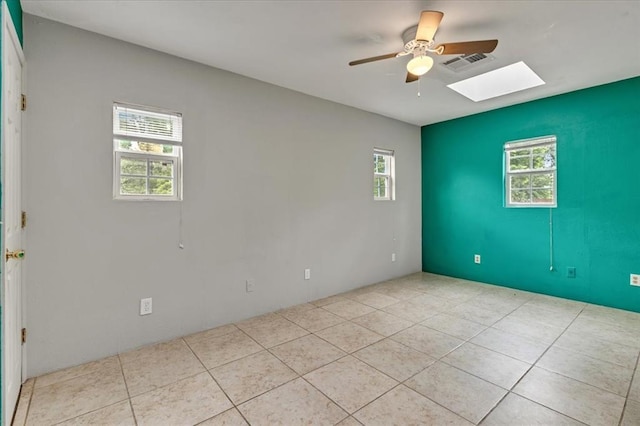 1126 SW 19th St, Oklahoma City, OK 73108 - empty room with a ceiling fan, tile patterned floors, a skylight, and plenty of natural light