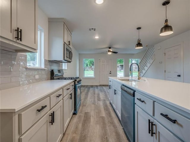 1021 NE 18th St, Oklahoma City, OK 73111 - kitchen with appliances with stainless steel finishes, a sink, light wood finished floors, light countertops, and recessed lighting