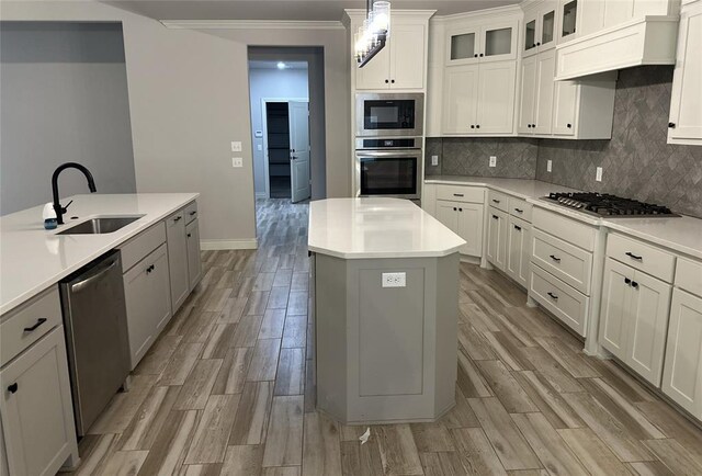 14709 Chambord Dr, Yukon, OK 73099 - kitchen featuring stainless steel appliances, a sink, a center island, light countertops, and crown molding