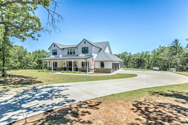 6301 144th Ave NE, Newalla, OK 74857 - modern farmhouse style home featuring curved driveway, a porch, a standing seam roof, a front lawn, and stone siding