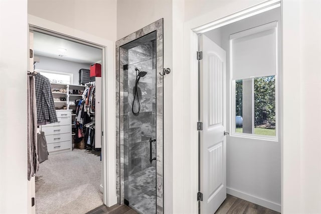 6301 144th Ave NE, Newalla, OK 74857 - bathroom with a shower stall, a walk in closet, wood finished floors, and baseboards