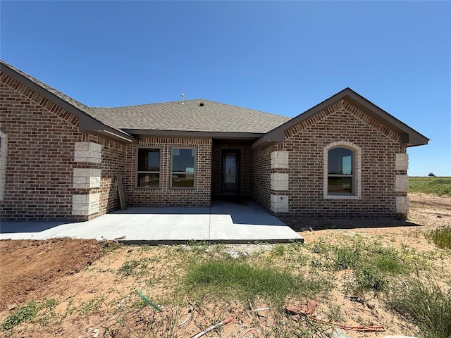 5 Old Glory Ave, Altus, OK 73521 - view of front of home with brick siding, a patio, and a shingled roof