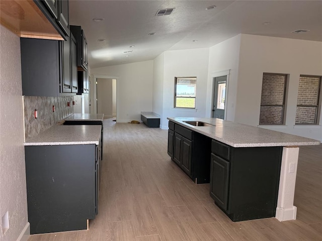 5 Old Glory Ave, Altus, OK 73521 - kitchen with lofted ceiling, light wood-style floors, a center island with sink, light countertops, and open floor plan